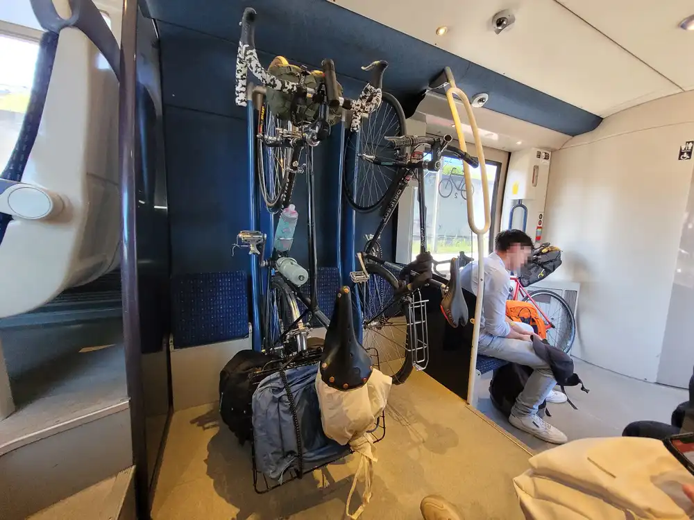 Space with 2 bicycles placed vertically between 3 foldable seats next to the entrance