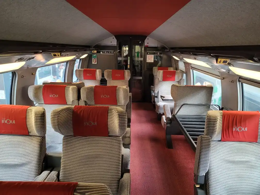 First class seats with a luggage rack between two seats