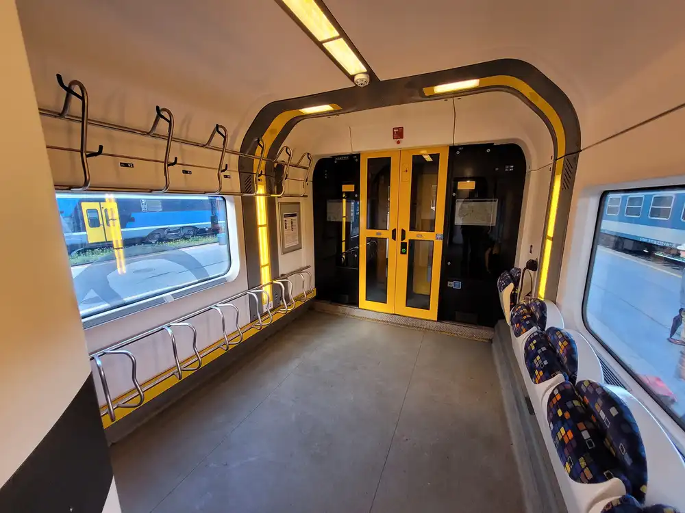 Bicycle room with vertical hooks and foldable seats in a modern train