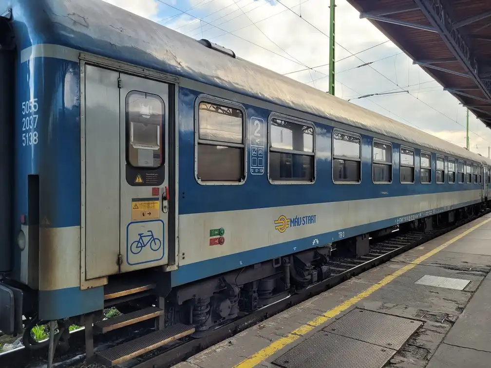 Traditional train carriage with a bicycle logo on the door on a platform