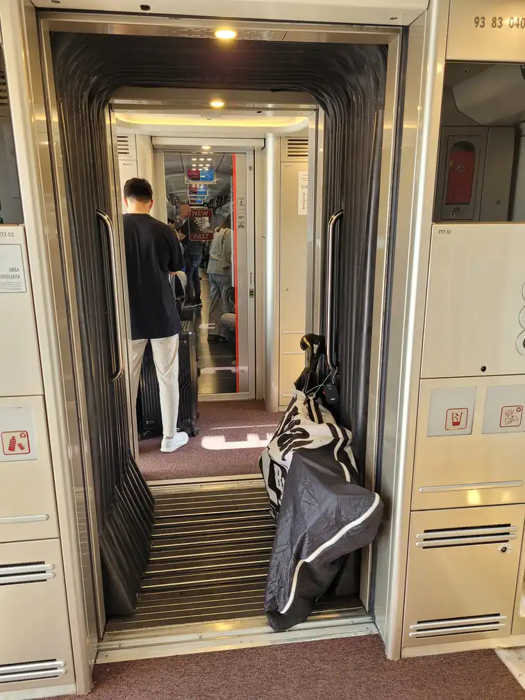 Packed bicycle in the corridor between entrance doors in a Frecciarossa 1000 train