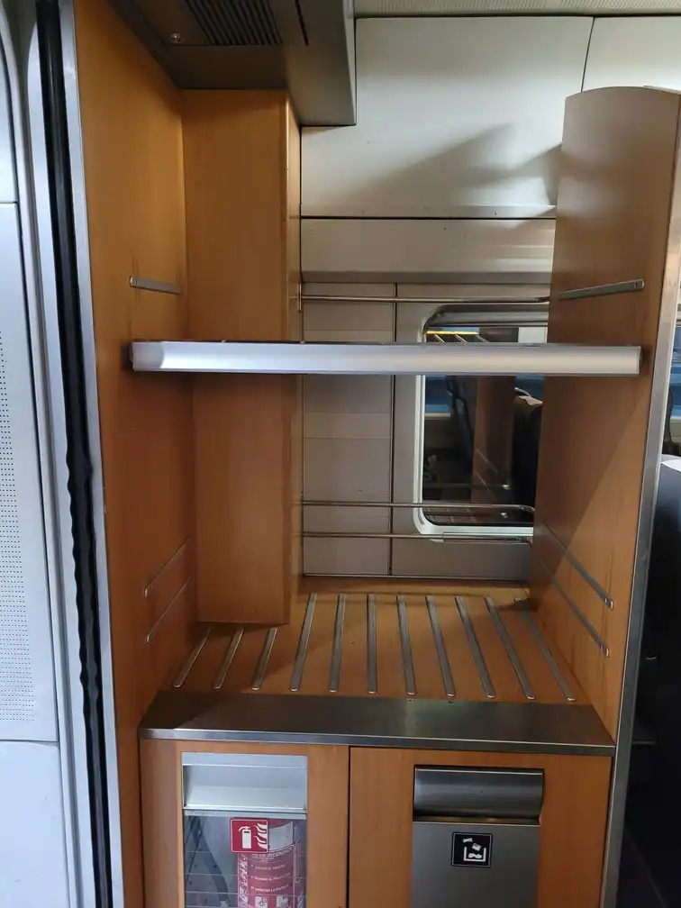 Luggage rack above trash bins in a Renfe series 102