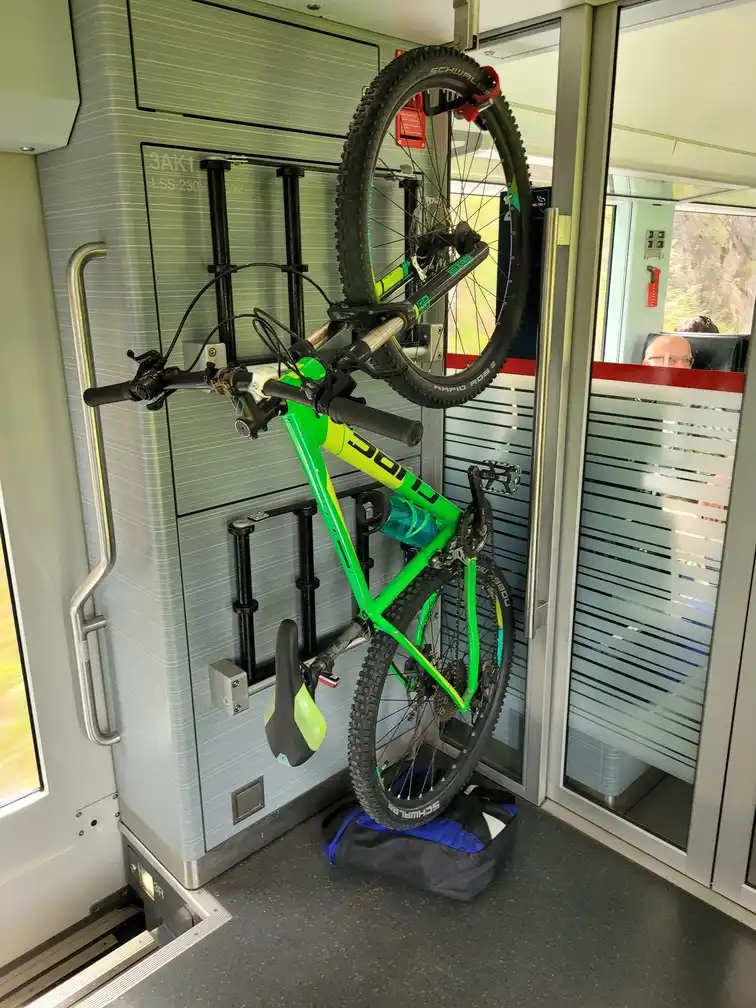 Mountain bike stored vertically next to folded ski racks