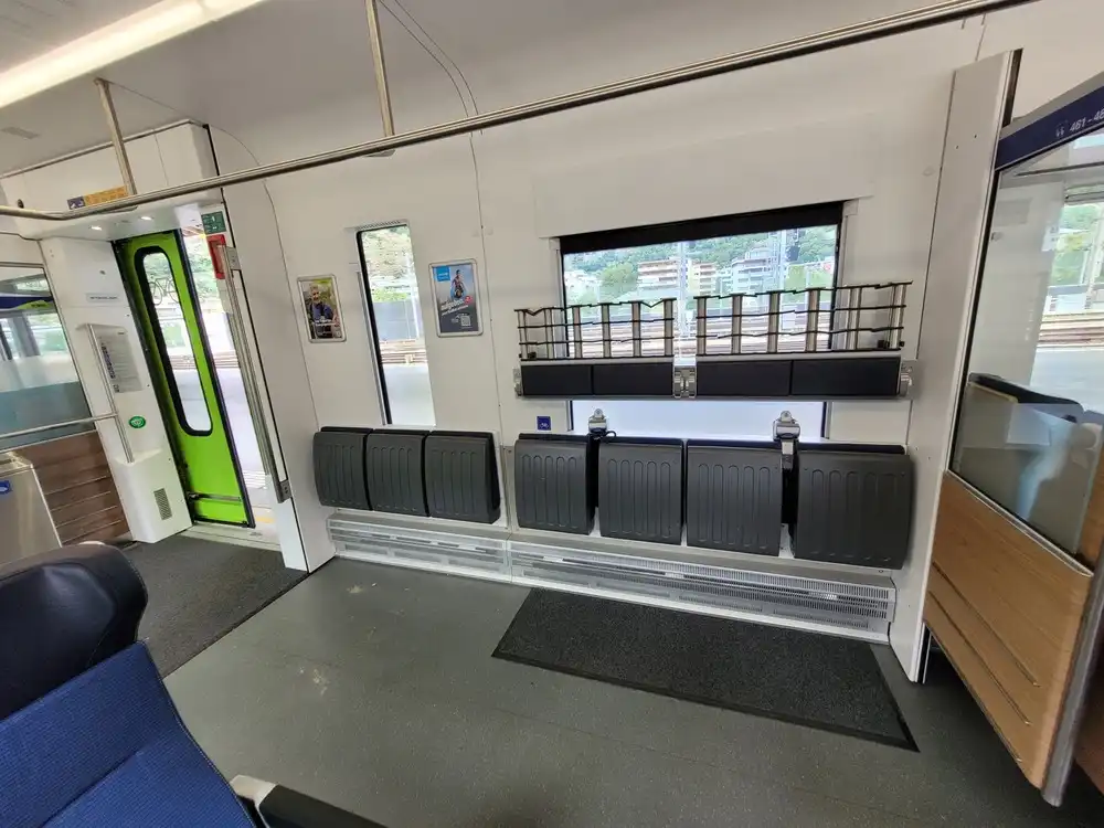 Train corridor with folded ski racks above folded seats